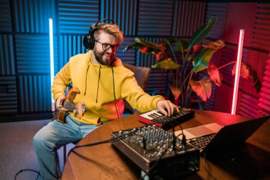 Ses mühendisi butik kayıt stüdyosundaki miksaj panelinde çalışıyor.