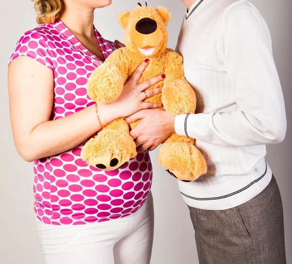 Mulher grávida com marido e brinquedo — Fotografia de Stock