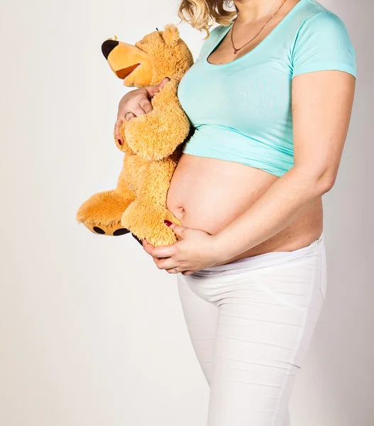 Mujer embarazada con juguete en su vientre — Foto de Stock