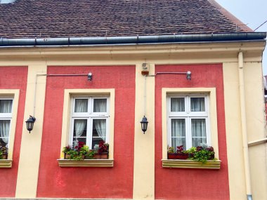 Pencereler ve çiçek kutularıyla simetrik konut cephesi. Kentsel mimari, Avrupa sokak detayları ve günlük şehir estetiği.