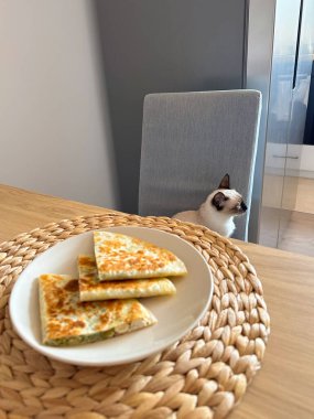 Tavada kızartılmış ekmek dilimleri evdeki ahşap yemek masasında servis edilir. Sıcak kahvaltı anı, günlük ev yemeği rutini ve sakin bir sabah yaşam tarzı..