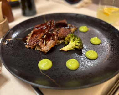 Brokoli ve yeşil soslu gurme et yemeği. Güzel yemekler, modern yemekler, restoran sunumu ve aşçılık estetiği..