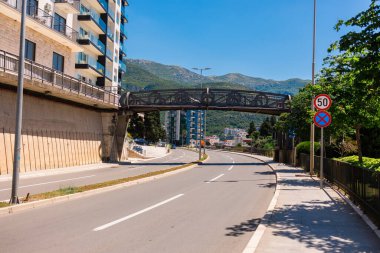 Yaya köprüsü ve trafik işaretli şehir yolu. Modern bir şehir ortamında yapısal hareketlilik, altyapı planlaması ve güvenli navigasyon