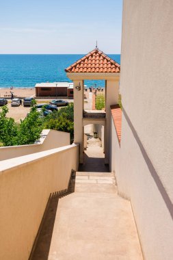 Deniz manzarasına bakan merdivenleri olan mimari bir geçit. Geçiş, uzamsal derinlik ve kıyı yaşam tarzı kentsel tasarım ve görsel yön ile ifade edilir. Karadağ.