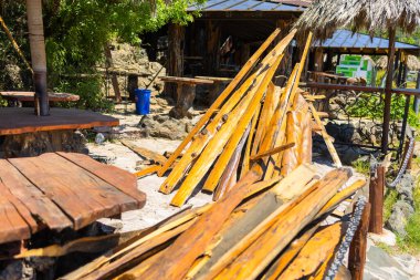 Kırsal alan yakınındaki ahşap kalaslar istiflenmiş. Malzemelerin yeniden kullanımı, yenileme süreci, ve el yapımı atmosfer konukseverlik ve doğal çevre içinde