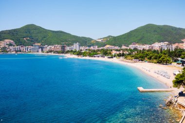 Budva Körfezi 'nin panoramik manzarası. Şehir plajı ve dağları var. Kıyı kenti ahengi, yaz turizmi cazibesi, Akdeniz manzarası ve Karadağ 'da gevşek deniz havası.
