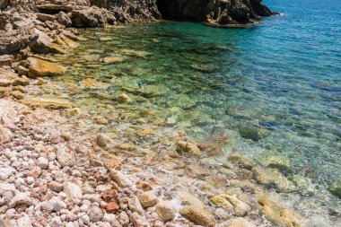 Karadağ 'ın saydam deniz suyu ve taş plajlı kayalık kıyı şeridi. Kıyı doğası, berraklık, yaz seyahati ve Budva yakınlarında yavaş deniz deneyimi..