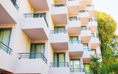 Modern bina cephesinde yumuşak pastel tonlarla tekrarlanan balkonlar. Mimari ritim, kentsel yaşam estetiği ve modern yerleşim ortamlarını şekillendiren yapısal tasarım.