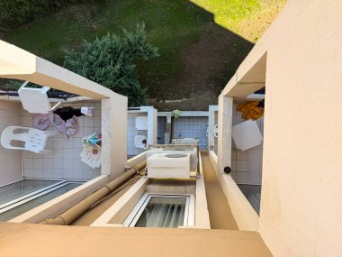 Plastik sandalyeli küçük balkon, korkuluklar ve asılı havlular. Mimarlık, konaklama, yaşam tarzı, seyahat evleri ve dış çevre