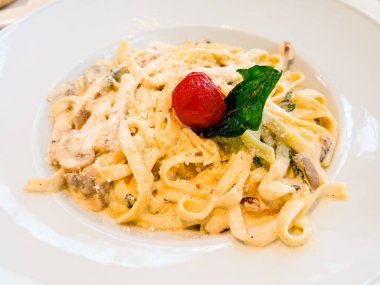Parmesanlı, mantarlı ve domatesli makarna. Restoran yemek kültüründe mutfak, beslenme ve yaşam tarzı anları
