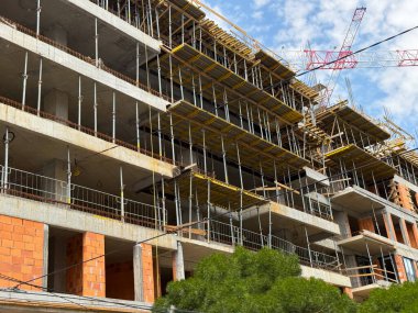 Görünür beton zemini ve iskelesi olan inşaat halinde bir bina. Kentsel gelişim, inşaat mühendisliği ve modern altyapı ilerlemesi