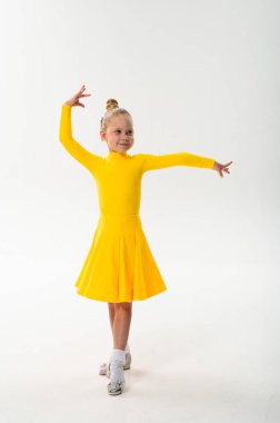Parlak sarı elbiseli gülen çocuk işitme cihazıyla koreografi çalışıyor. Sağırlığa rağmen hareketin özgüven, konsantrasyon ve ahengi, çocuk sanatında ve dansında ekleme ve teknolojik ilerlemeyi gösteriyor