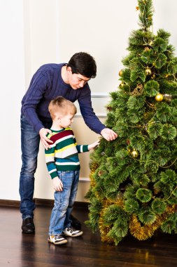 Çocuk babasıyla evde Noel ağacı süsleme