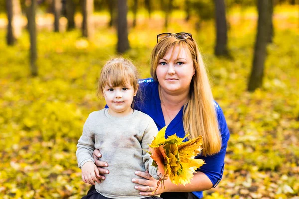 Rodina: matka a dítě malá dcera hrát mazlení na podzimní procházku v přírodě — Stock fotografie