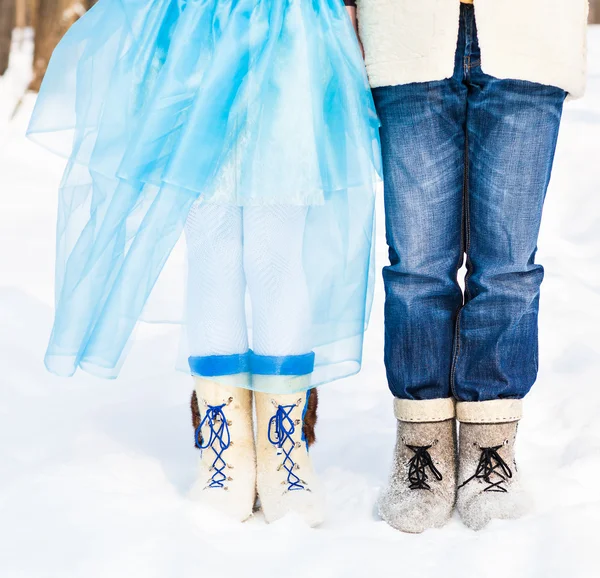 Piernas abrazando parejas de pie sobre la nieve invierno nevado — Foto de Stock