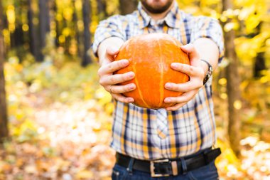 Gülümseyen adam bir parkta kabak taşıyan