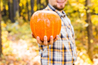 Gülümseyen adam bir parkta kabak taşıyan