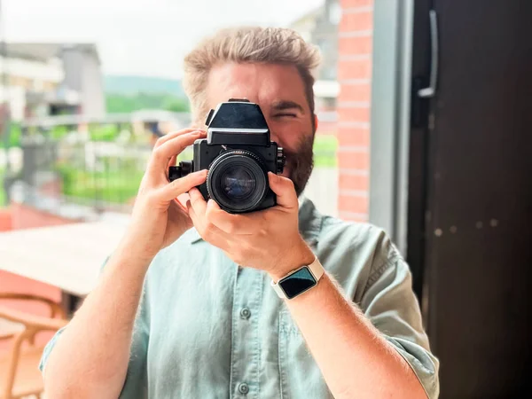 Kamera tutan ve restoran penceresinin yanında fotoğraf çeken bir adam. Fotoğraf, yaratıcılık ve yaşam tarzı etkinliği eğlence ve konukseverlik ortamında yakalanır.