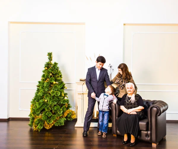 Счастье, поколение, праздники, люди понятие - счастливая семья сидит на диване. Рождество и Новый год — стоковое фото