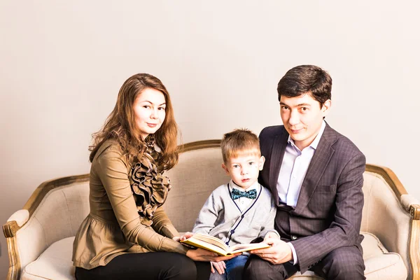 Портрет дружелюбной семьи, читающей книгу на Рождество — стоковое фото