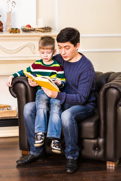 Padre e figlioletto che leggono il libro la sera di Natale — Foto Stock