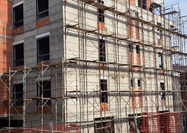 Yapı iskelesi olan inşaat halindeki konut binası. Kentsel kalkınma, mimari ilerleme, yatırım, altyapı ve gayrimenkul büyüme kavramı