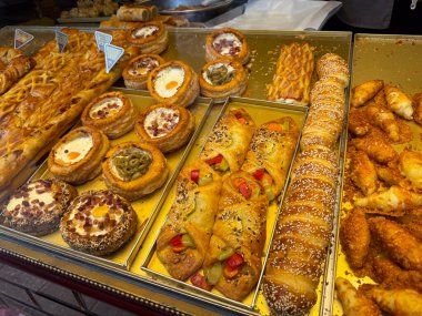 Lezzetli hamur işi ve yumurtalı tart seçimi ile birlikte fırın vitrininde. Sokak yemekleri kültürü, kahvaltı seçimi, aşçılık çeşitliliği, gastronomi geleneği, perakende satış..