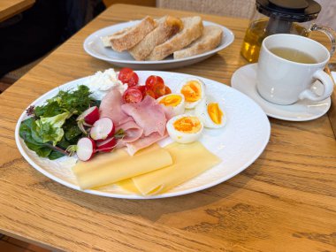 Kahvaltı tabağını yumurta ve jambonla kapat. Protein besin, taze malzemeler ve kafe yemeği konsepti.
