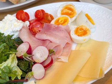 Kahvaltı tabağını yumurta ve jambonla kapat. Protein besin, taze malzemeler ve kafe yemeği konsepti.
