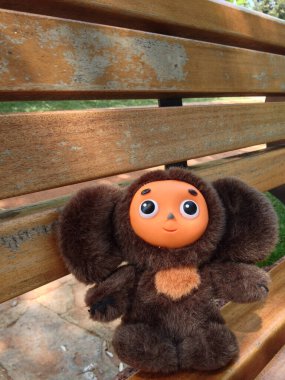 Pelüş oyuncak Cheburashka parktaki ahşap bankta tek başına oturuyor. Çocukluk anısı, yalnızlık, nostalji ve hayal gücü.
