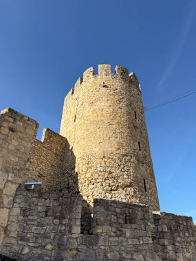 Belgrad 'da mavi gökyüzünün altındaki tuğla duvarın arkasındaki tarihi kale kulesi. Kentsel çevrede miras, mimari ve kültürel koruma.