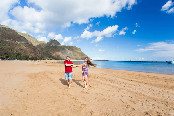 Gelukkig paar loopt op het strand. — Stockfoto