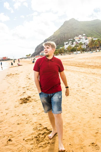 Glimlachende man op het strand — Stockfoto