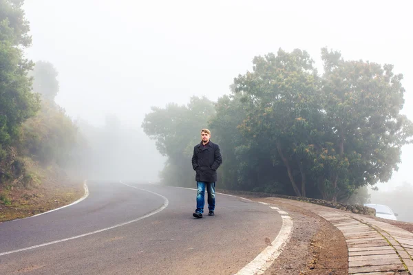 Hombre caminando en un bosque brumoso — Foto de Stock