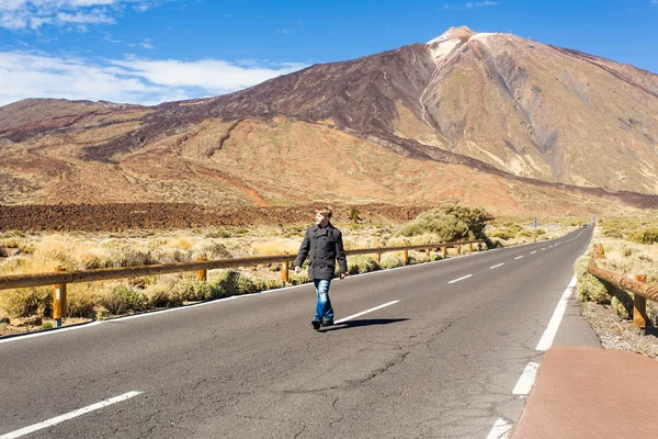 Homem caminhando em uma estrada — Fotografia de Stock