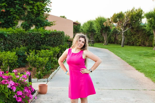 Jeune femme en robe rose posant sur le parc d'été — Photo