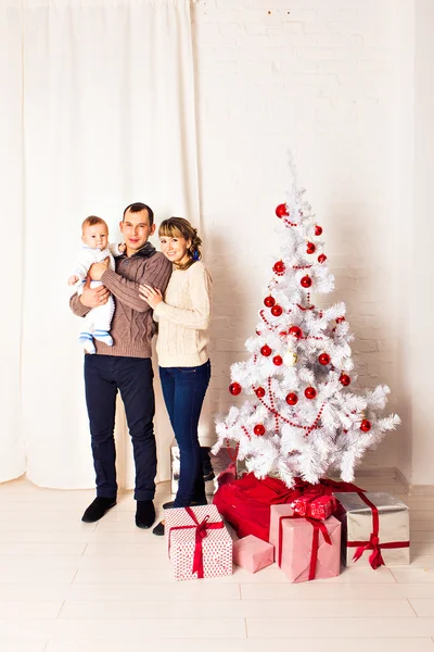 Retrato familiar de Navidad en casa Sala de estar de vacaciones, niños y bebés con caja de regalo presente, decoración de la casa por la guirnalda de velas del árbol de Navidad — Foto de Stock