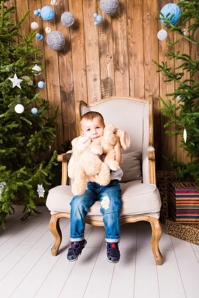 Menino alegre brincando com seu brinquedo perto da árvore de Natal — Fotografia de Stock