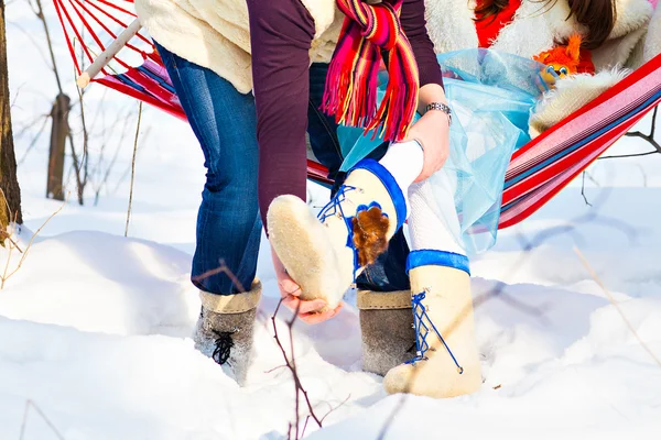 Мужчина помогает жене надеть зимнюю обувь — стоковое фото