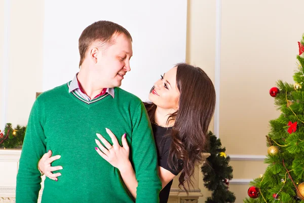 Jovem casal feliz perto de uma árvore de Natal — Fotografia de Stock