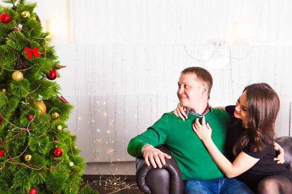 Junges glückliches Paar in der Nähe eines Weihnachtsbaums — Stockfoto