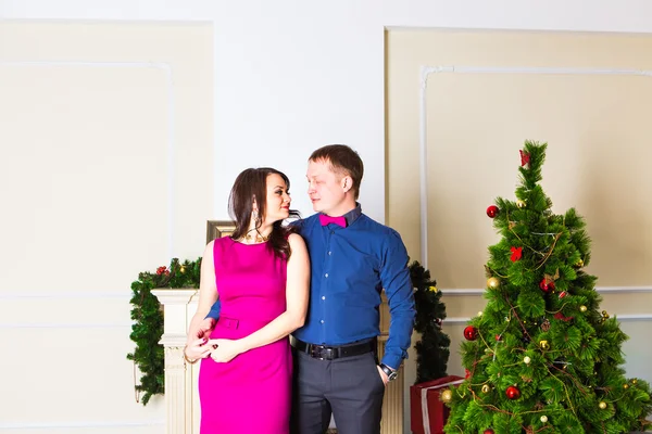 Jovem casal feliz perto de uma árvore de Natal — Fotografia de Stock