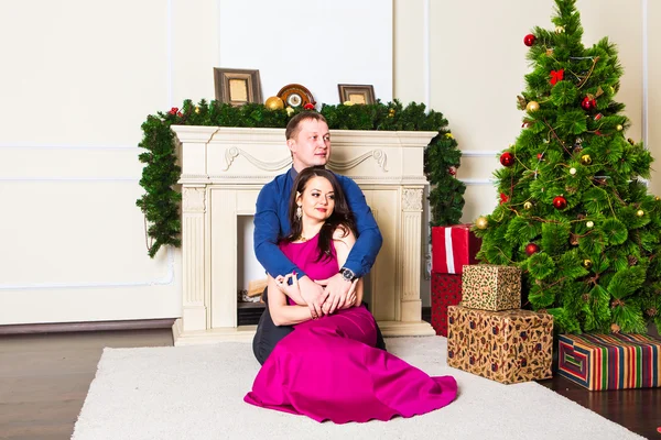 Mladý šťastný pár v blízkosti vánočního stromu — Stock fotografie