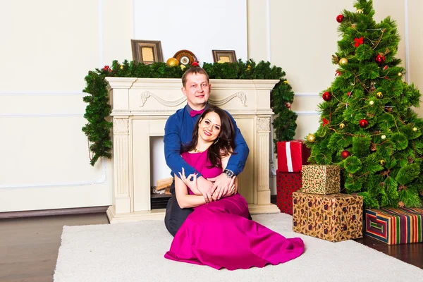 Junges glückliches Paar in der Nähe eines Weihnachtsbaums — Stockfoto