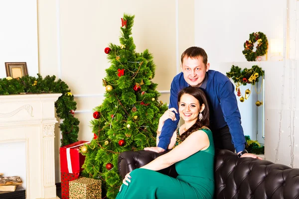 Junges glückliches Paar in der Nähe eines Weihnachtsbaums — Stockfoto
