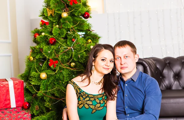 Joven pareja feliz cerca de un árbol de Navidad —  Fotos de Stock