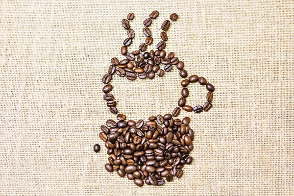 Кофейная чашка кофейных зерен на текстуре мешковины — стоковое фото