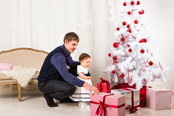 Niña jugando con su padre cerca del árbol de Navidad — Foto de Stock