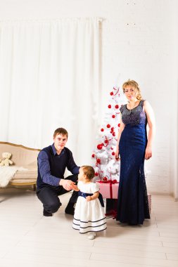 Üç kişi ve köknar ağacı hediye kutuları ile Noel ailesi