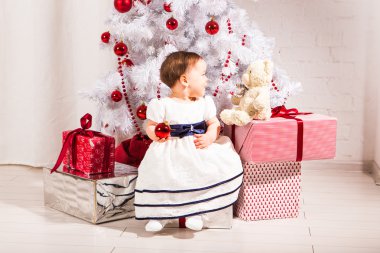 Noel ağacının yanında iskambil mutlu küçük yürümeye başlayan çocuk kız